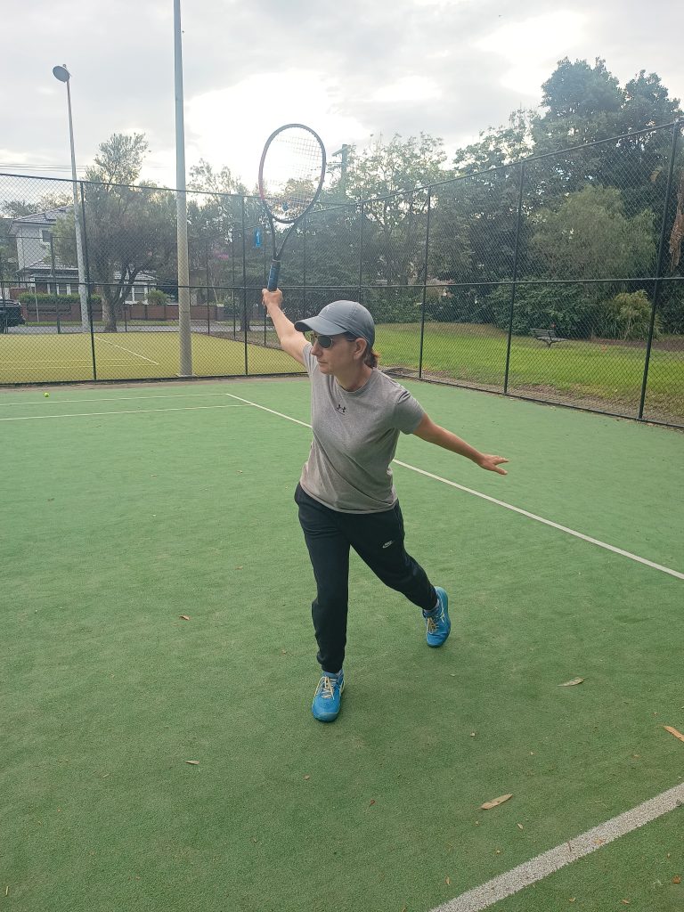 Tennis coach kim freebairn demonstrating a one handed backhand